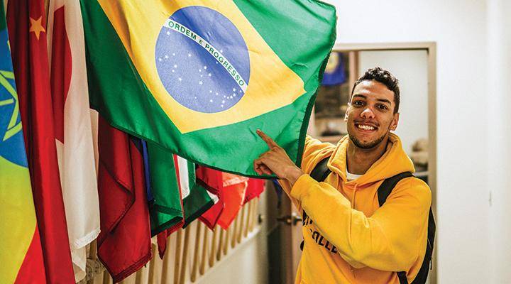 An international student poses with a flag