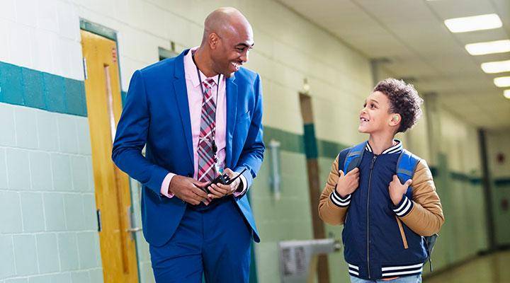 A school principal walks with a student