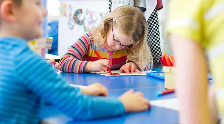 A student colors on paper