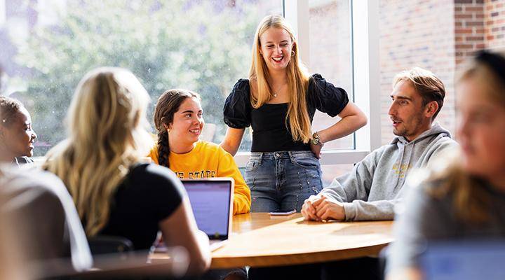 Students visit together at a table