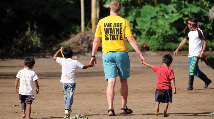 A WSC student guides children in an Ecuadorian village