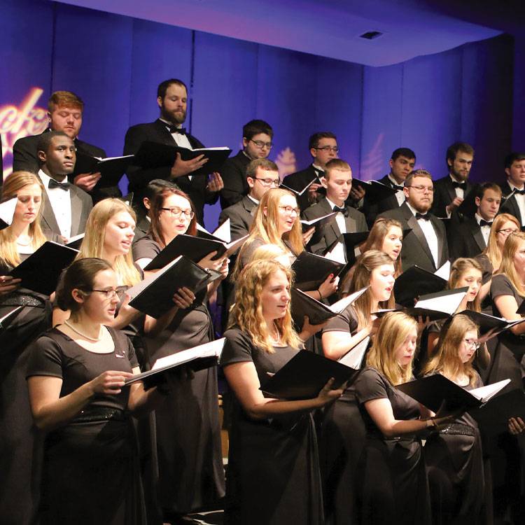 Students in a choir at WSC peform on stage.