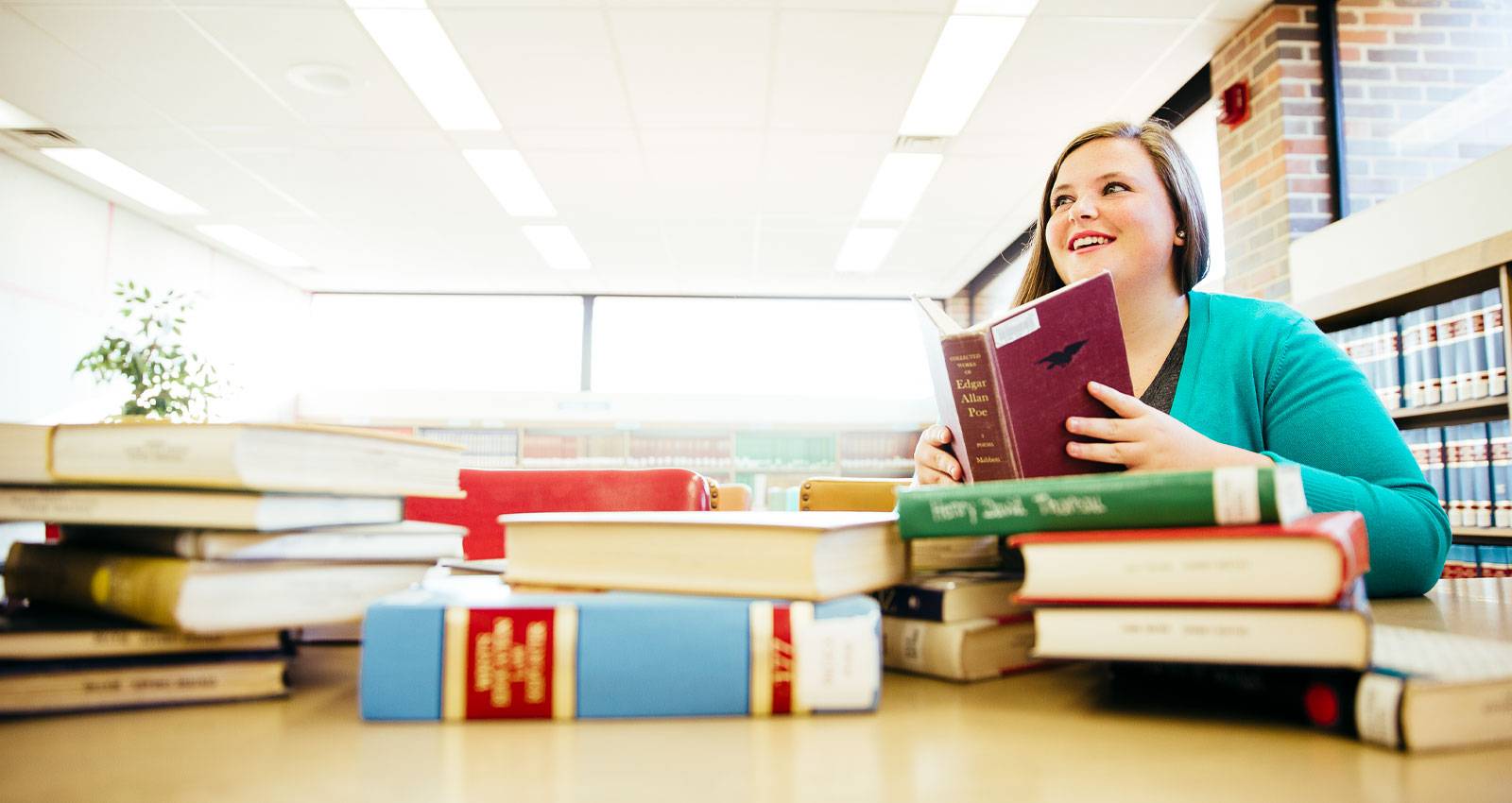 A WSC student surrounded by books.