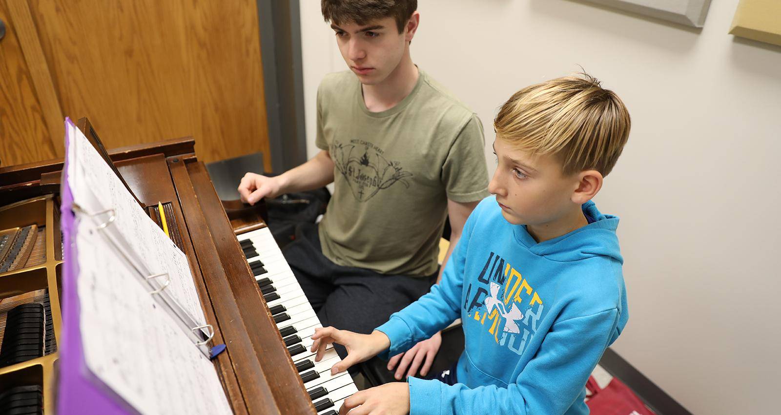 A young student takes piano lessons during 音乐学院