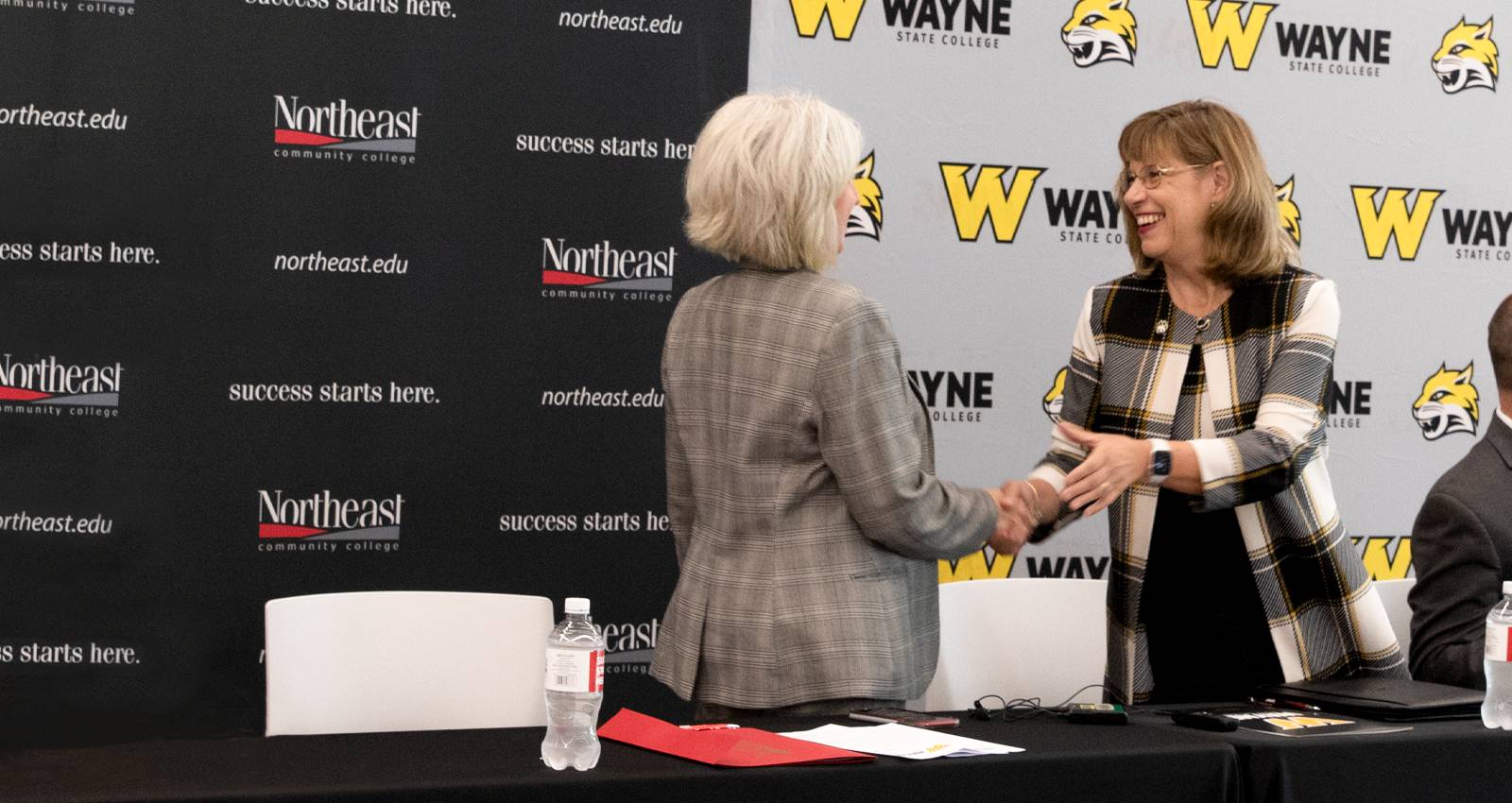 Dr. Maryz Rames shakes hands with Leah Barrett, President of NECC