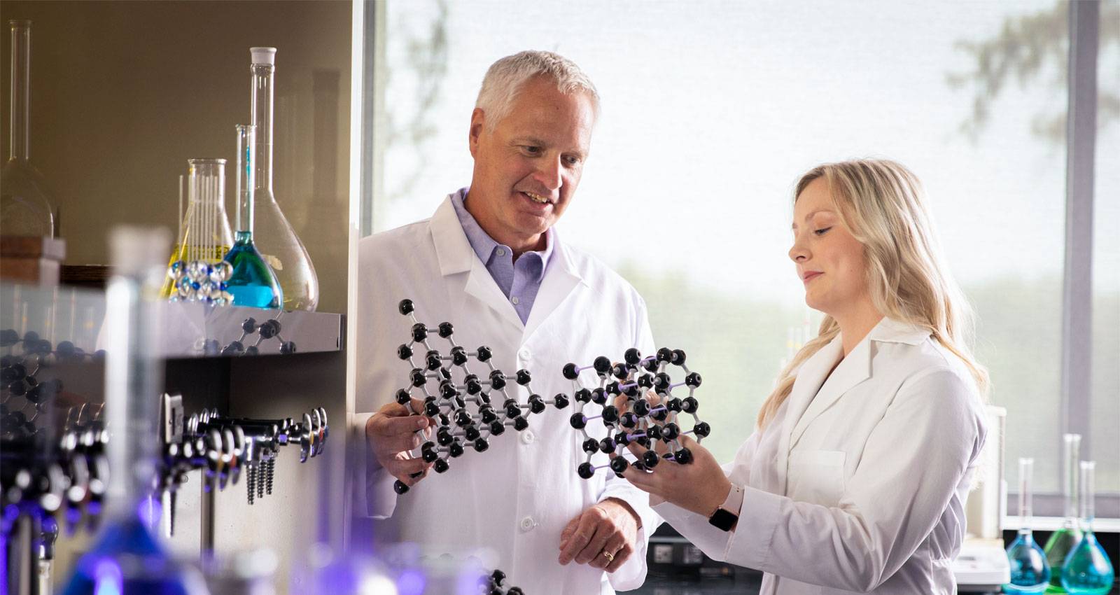 Dr. Dave Pietz works in a science lab with a WSC student.
