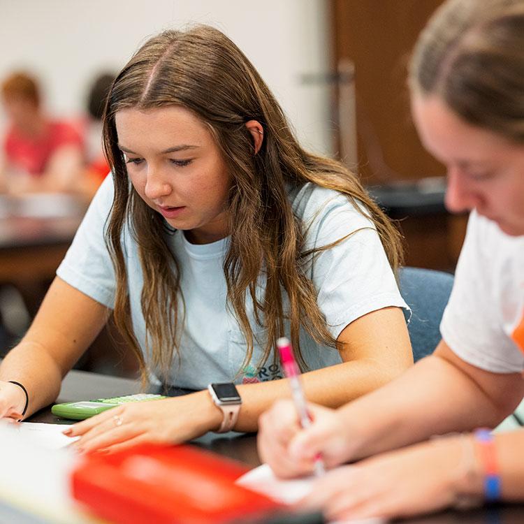 Two students work in a physics lab