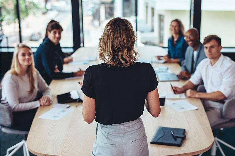 A woman talks to a group of business people