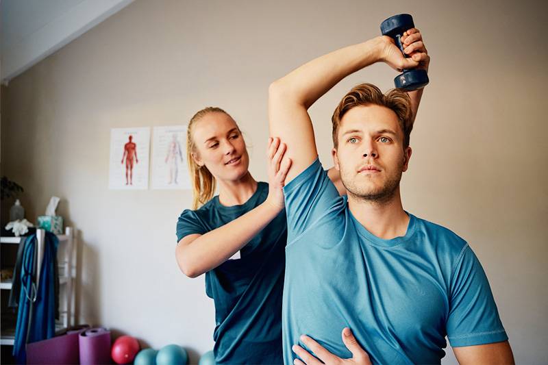 Pre-athletic training degree concept featuring a trainer working with a patient