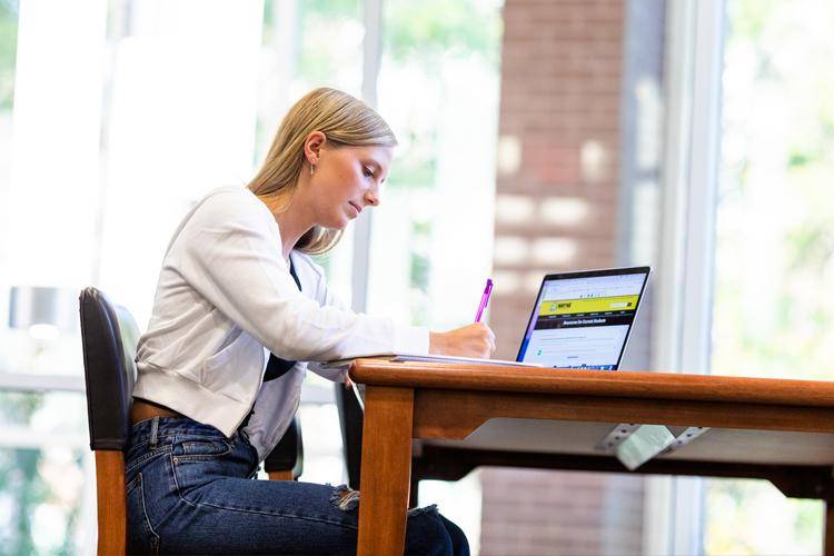 A WSC education student on her laptop